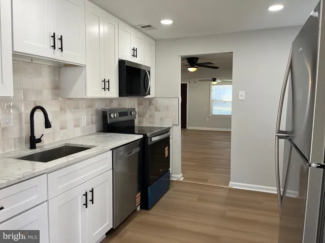 a kitchen with white cabinets and stainless steel appliances