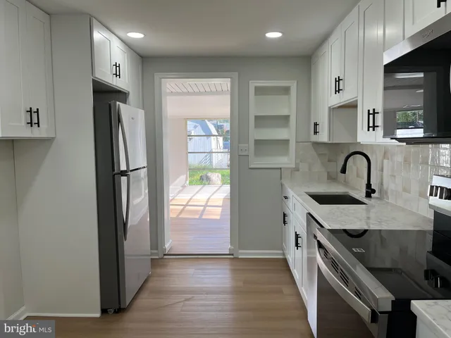 a kitchen with stainless steel appliances granite countertop a refrigerator a sink and a stove