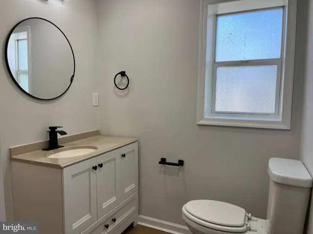 a bathroom with a toilet a sink and mirror