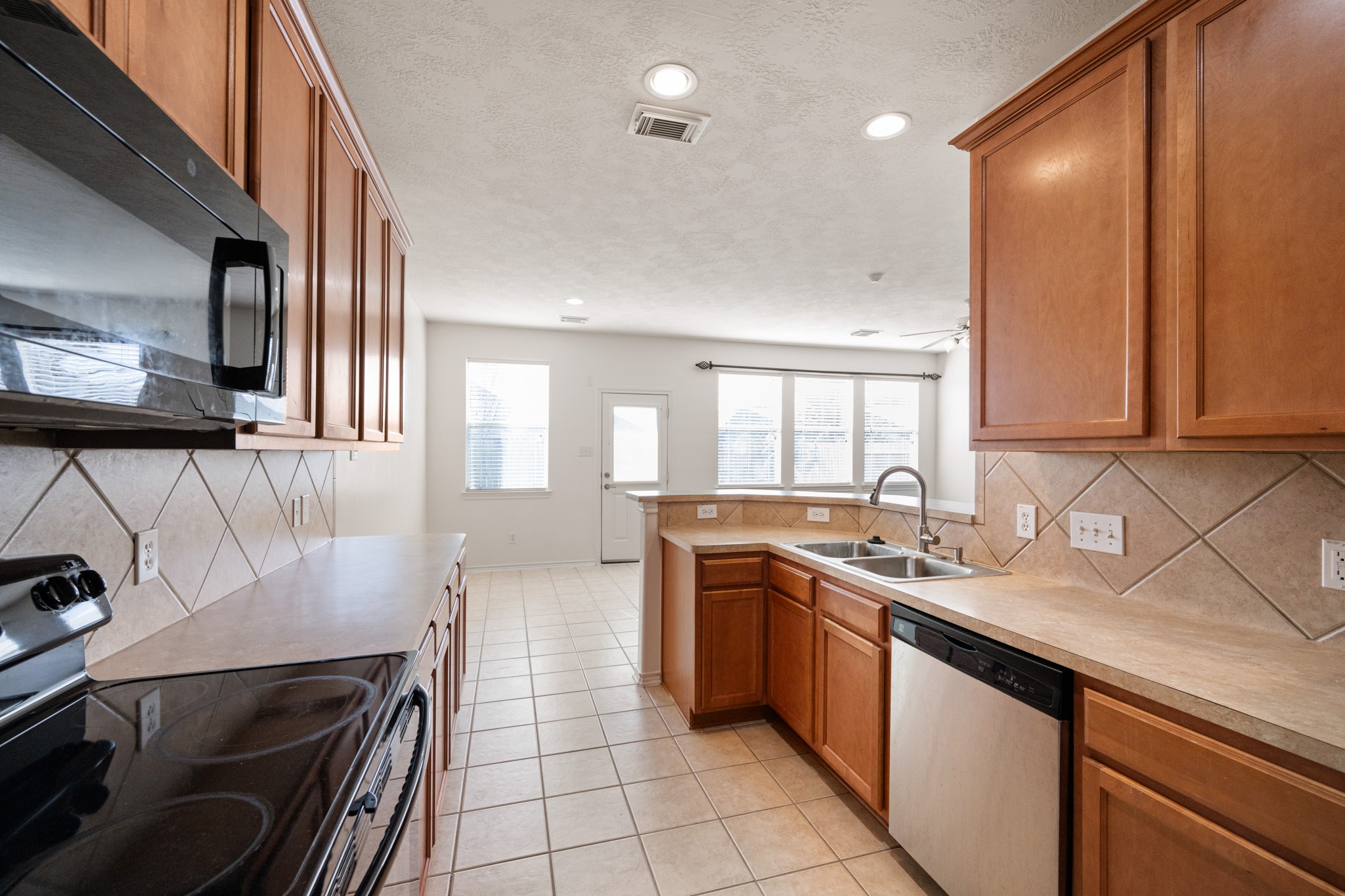 11938 Ramla Place Trail Houston, TX 77089 - Photo 12 of 28 This bright and inviting kitchen features sleek appliances, warm wood cabinetry, and a spacious layout perfect for culinary creativity and entertaining.