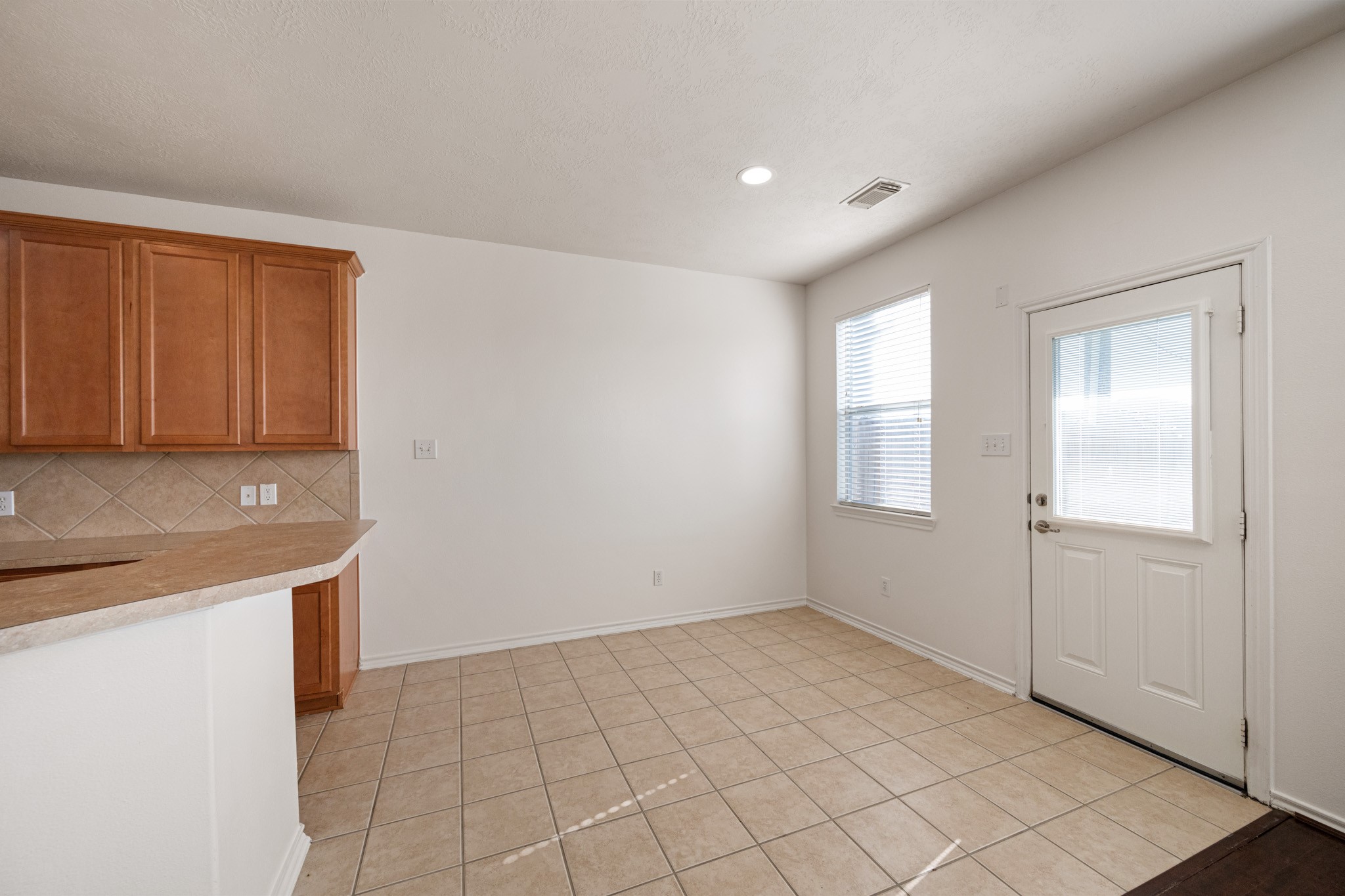 11938 Ramla Place Trail Houston, TX 77089 - Photo 13 of 28 This inviting breakfast area features warm cabinetry, a tile floor, and abundant natural light, creating the perfect spot to start your day.