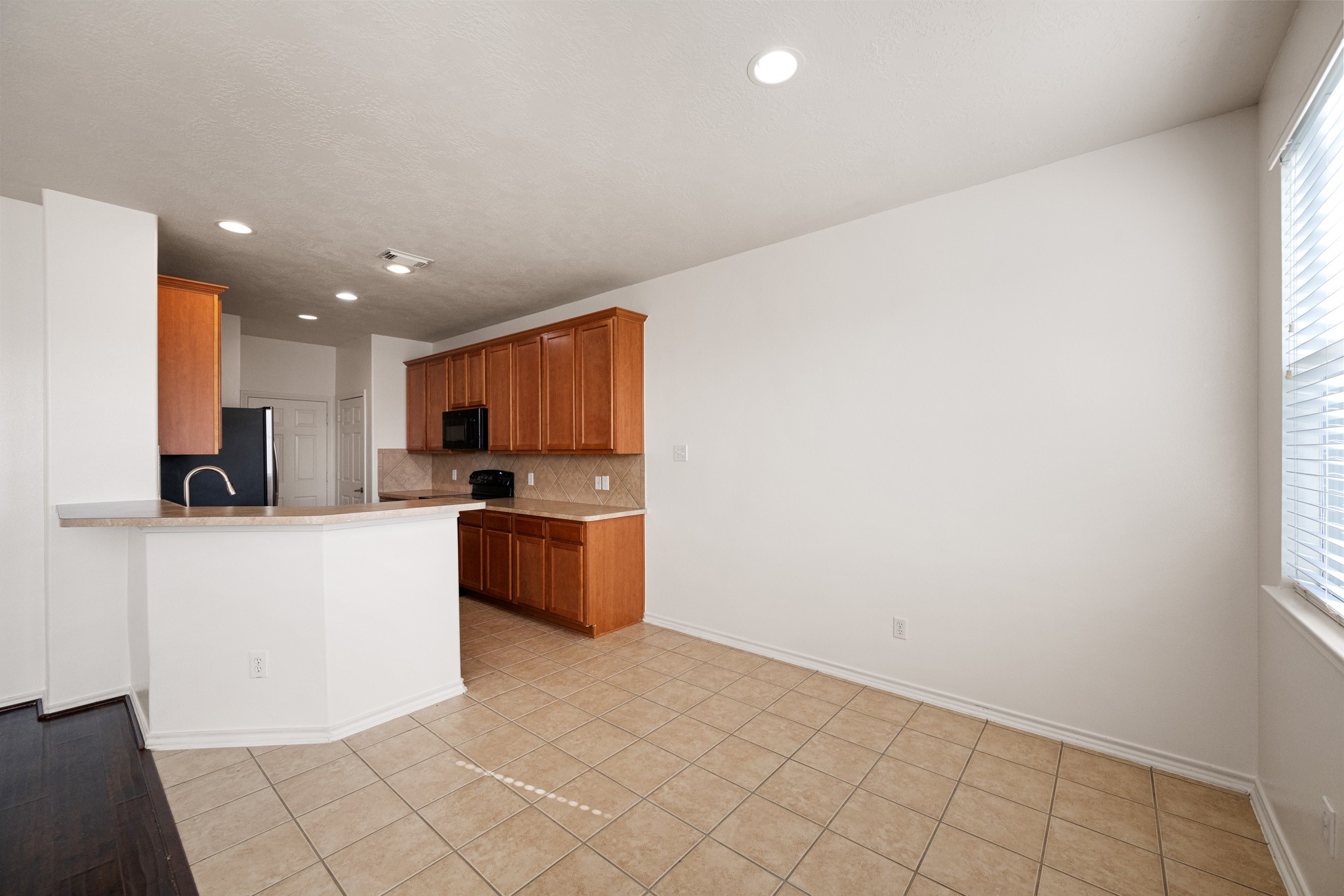 11938 Ramla Place Trail Houston, TX 77089 - Photo 14 of 28 This inviting breakfast area, bathed in natural light, seamlessly connects to a modern kitchen with sleek cabinetry and ample counter space, perfect for morning gatherings.