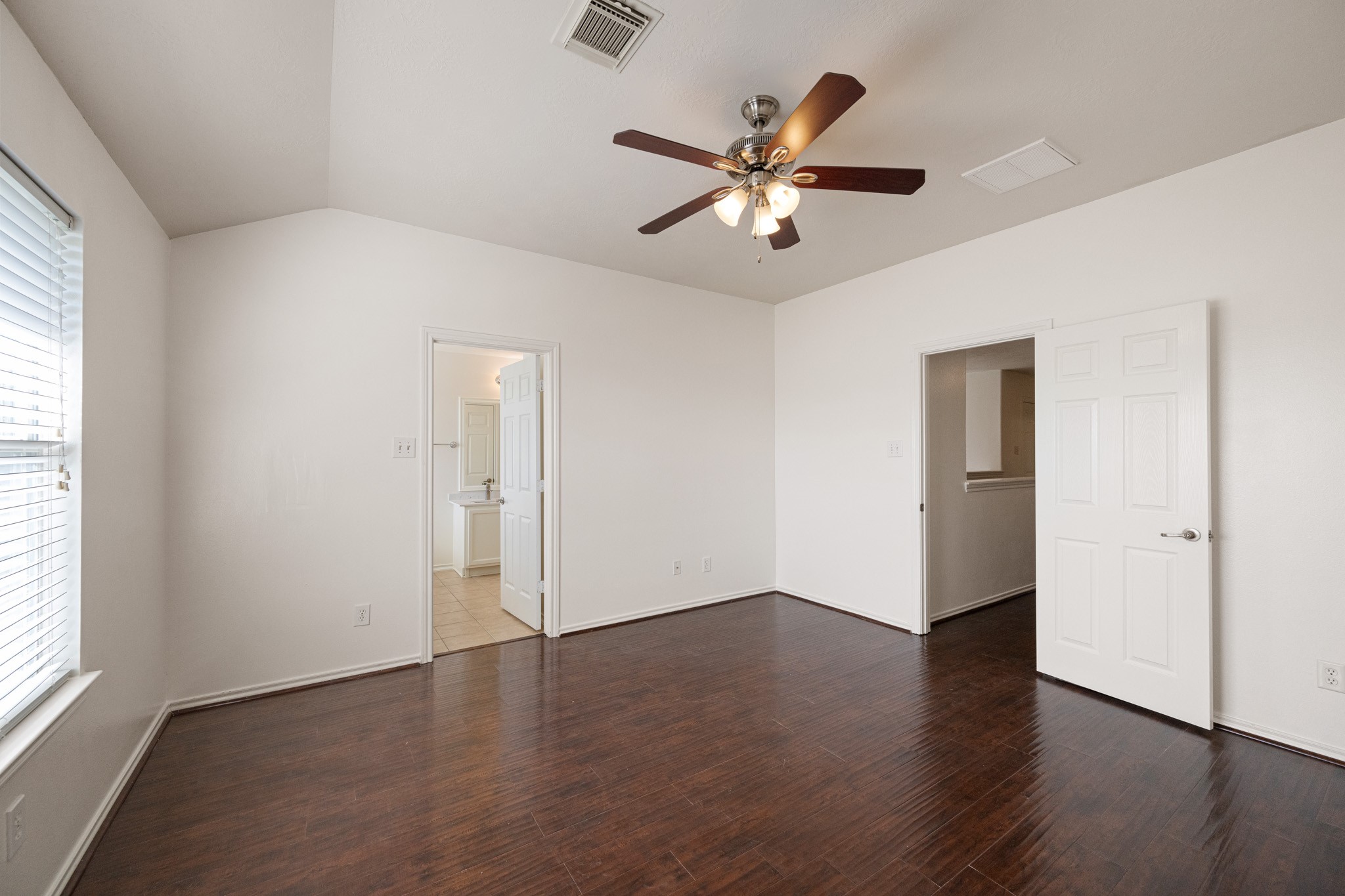 11938 Ramla Place Trail Houston, TX 77089 - Photo 18 of 28 This inviting primary bedroom features elegant floors, abundant natural light through large windows, and convenient en-suite access, creating a perfect blend of comfort and style.