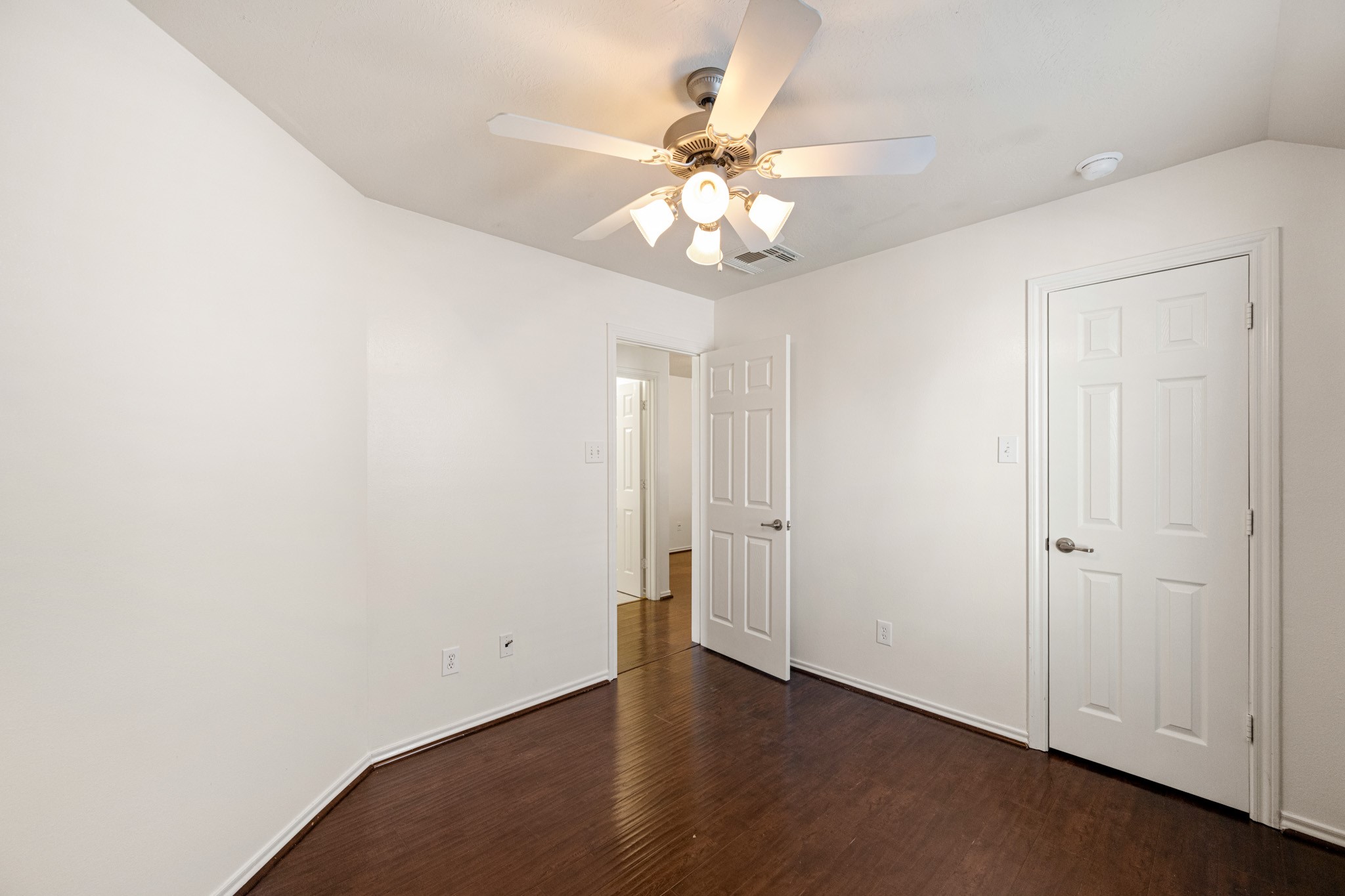 11938 Ramla Place Trail Houston, TX 77089 - Photo 24 of 28 Discover tranquility in Bedroom 2, featuring sleek hardwood floors, fresh white walls, and a stylish ceiling fan, perfect for creating your personal retreat.