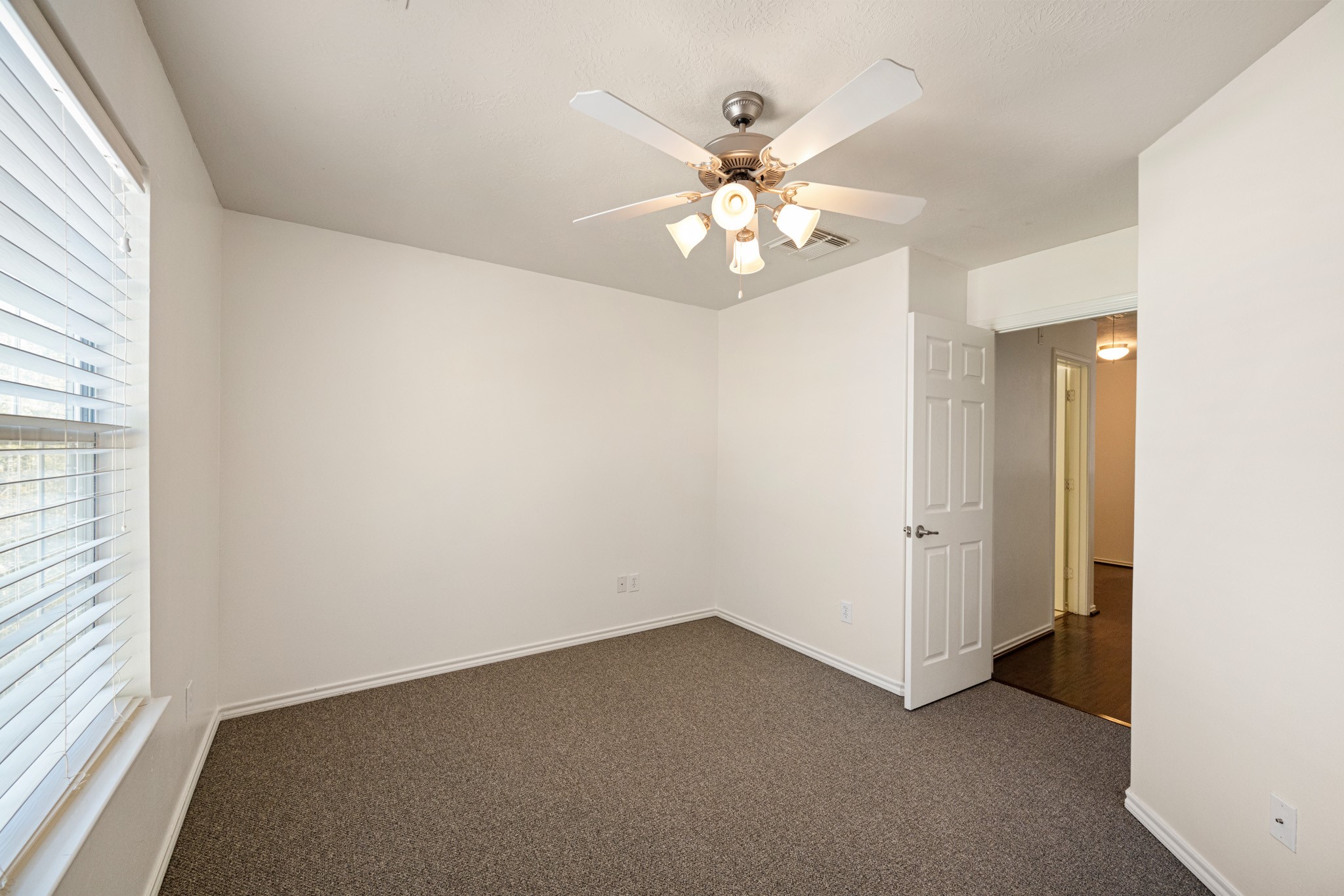 11938 Ramla Place Trail Houston, TX 77089 - Photo 26 of 28 This inviting third bedroom features ample natural light through its large window, complemented by a modern ceiling fan, offering a cozy and comfortable retreat.