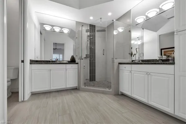 a bathroom with a double vanity sink a mirror and shower