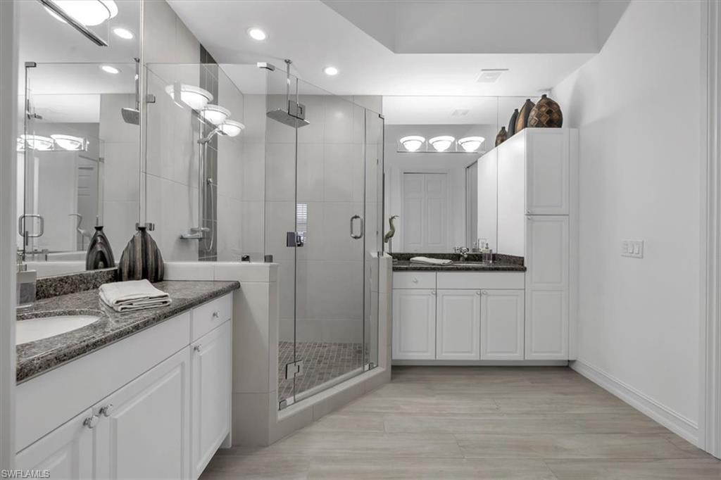 Undisclosed Address Naples, FL 34108 - Photo 26 of 44 a bathroom with a double vanity sink a mirror and shower
