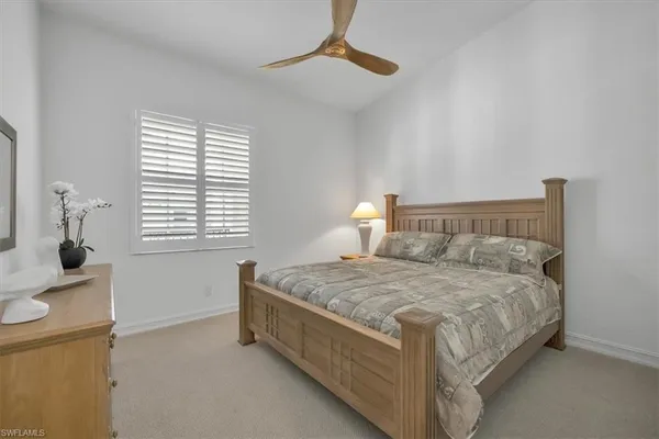 a bedroom with a bed and a lamp on the dresser