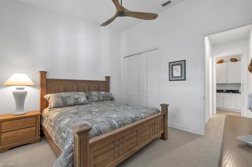 Undisclosed Address Naples, FL 34108 - Photo 37 of 44 a bedroom with a bed and a lamp on the dresser