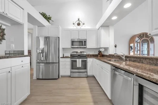 a kitchen with granite countertop a refrigerator stove and microwave