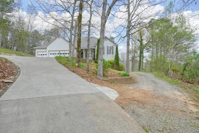 a living room with stainless steel appliances kitchen island granite countertop a refrigerator a stove a oven with white cabinets and wooden floor