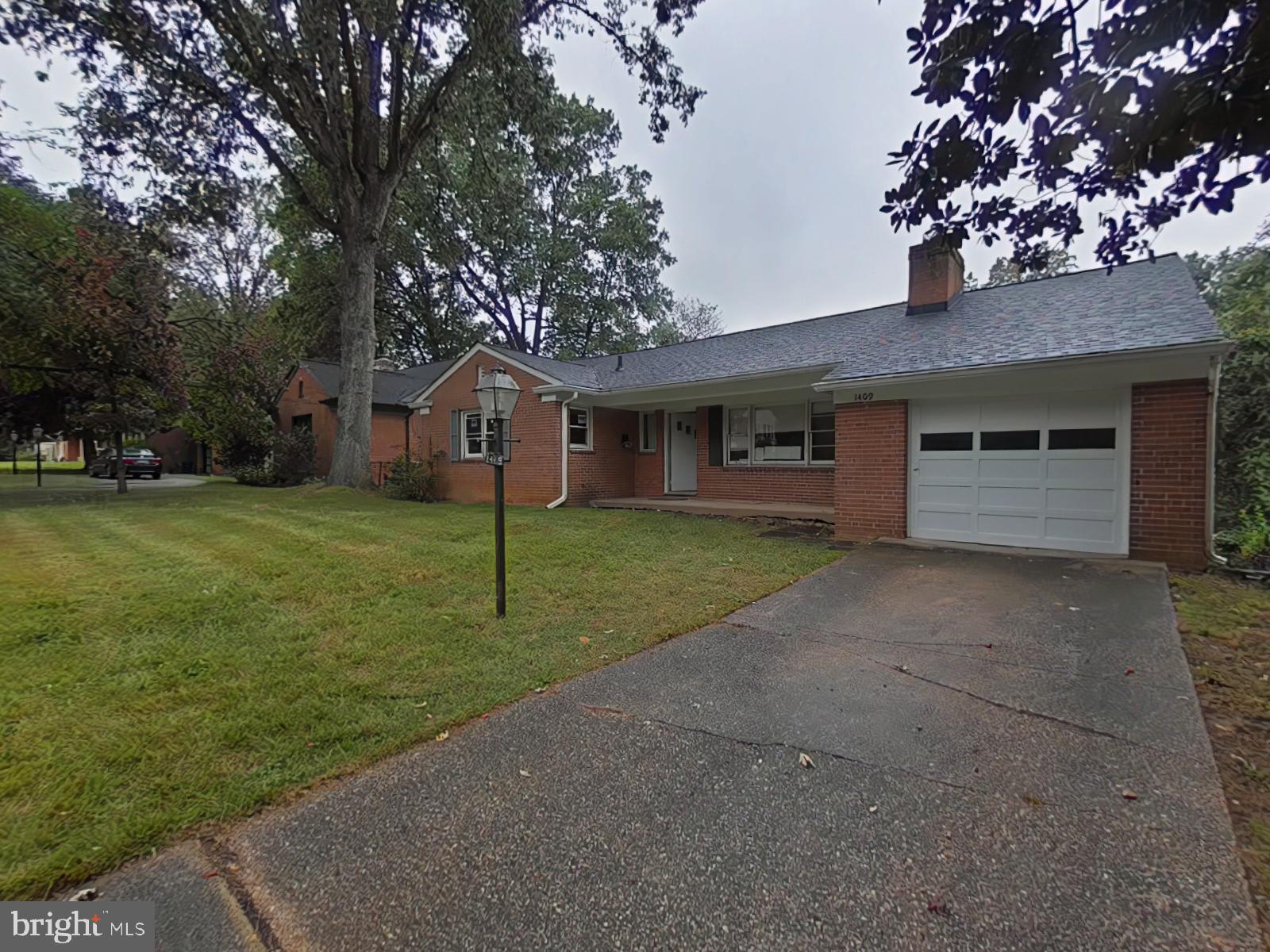 Charming brick home with lush greenery.