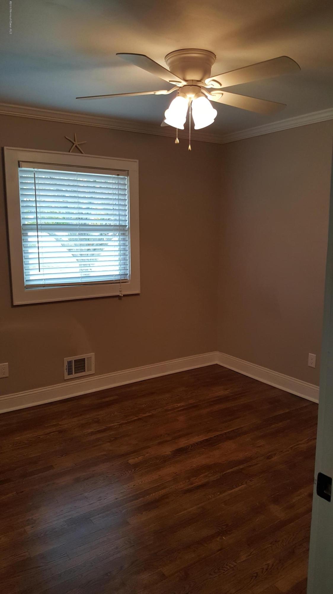 119 Meadowbrook Road Spring Lake Heights, NJ 07762 - Photo 16 of 24 a view of an empty room with wooden floor and a window
