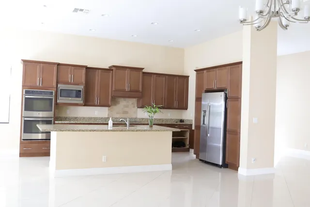 a kitchen with stainless steel appliances granite countertop a refrigerator and a stove top oven