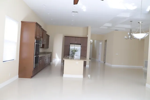 a kitchen with stainless steel appliances granite countertop a refrigerator a sink and a stove