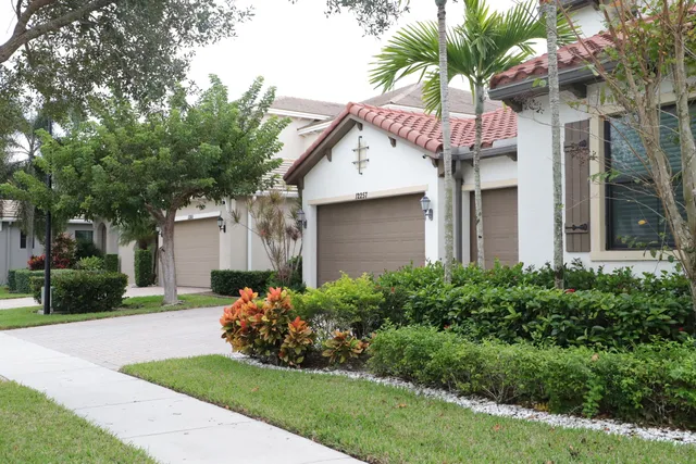 a front view of a house with a garden and trees