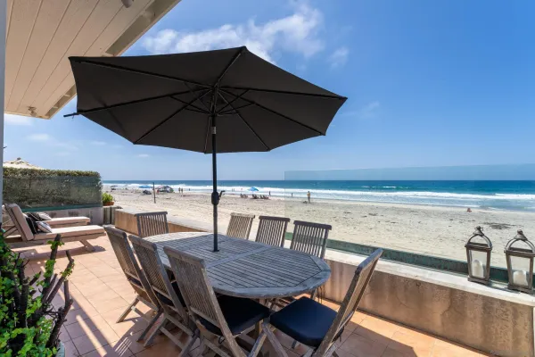 a view of a roof deck with table and chairs under an umbrella