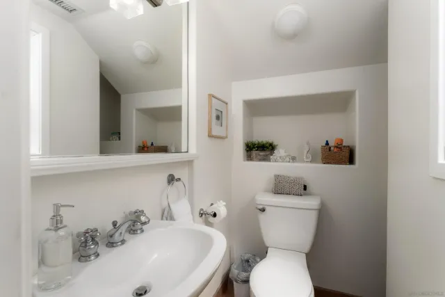 a bathroom with a toilet sink and mirror