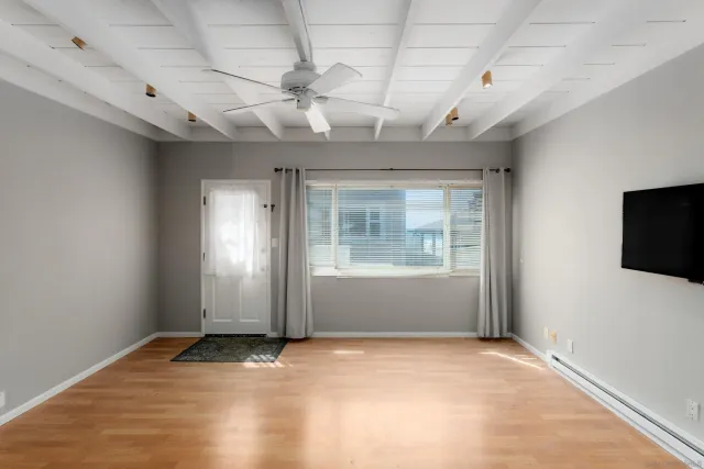 en empty room with windows and flat screen tv