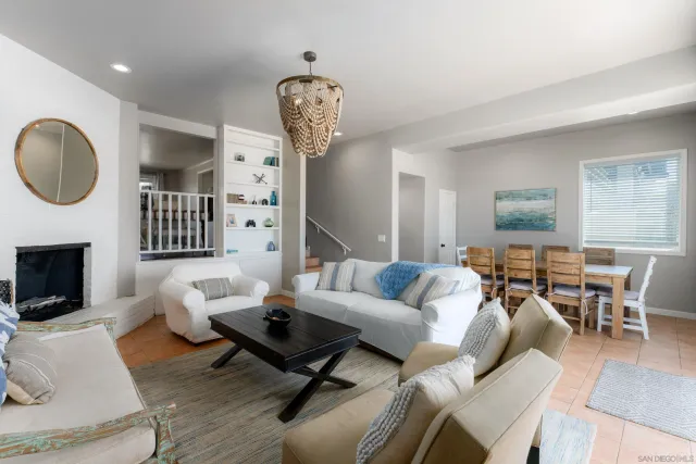 a living room with furniture a fireplace and a chandelier