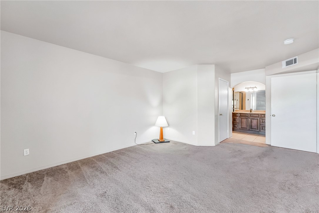 698 South Racetrack Road, Unit 1512 Henderson, NV 89015 - Photo 16 of 30 Plush carpeting anchors this spacious room leading directly to an adjacent vanity area.