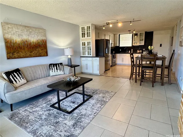 a living room with furniture a kitchen view and a kitchen view