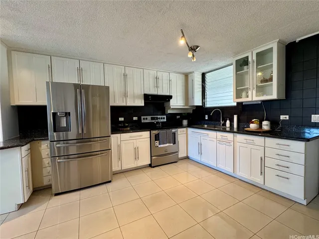a kitchen with white cabinets a refrigerator and a stove