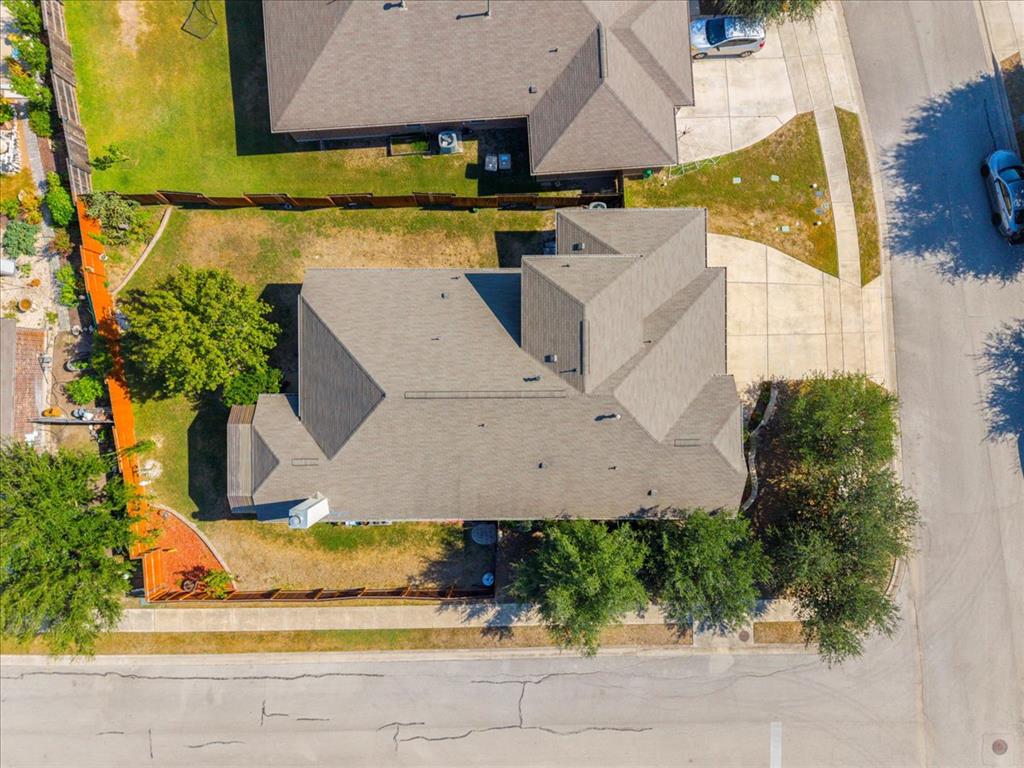 349 Razzmatazz Trail Buda, TX 78610 - Photo 7 of 27 An aerial perspective showcases a residence with a classic shingle roof, complemented by a private yard.
