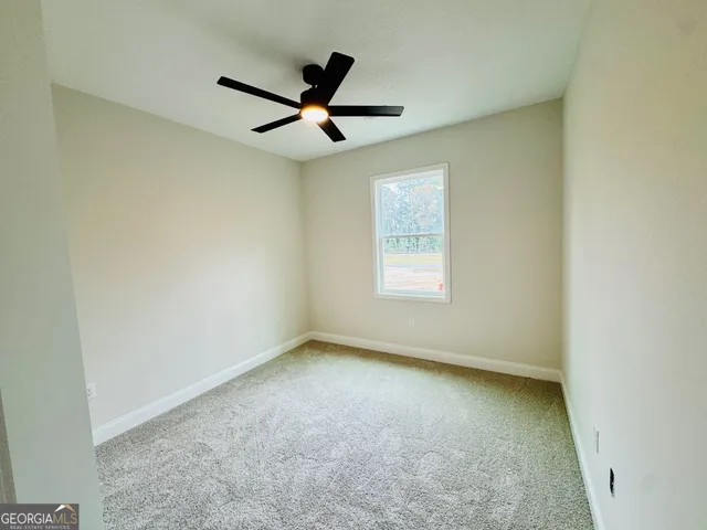 an empty room with a window and a fan
