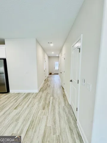 a view of a hallway with wooden floor