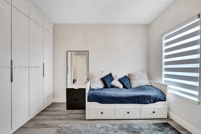 a bedroom with a bed and a large mirror