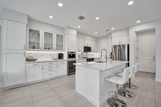 a kitchen with white cabinets and stainless steel appliances