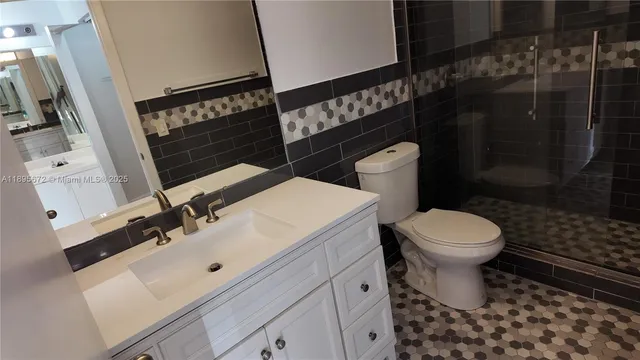 a bathroom with a sink toilet and shower