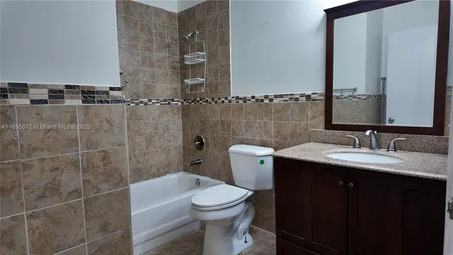 a bathroom with a granite countertop toilet sink and mirror