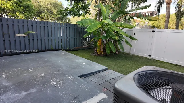 a view of backyard with wooden fence and a large tree