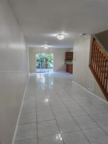 a view of hallway with stairs and a window