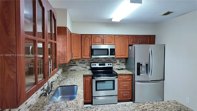 a kitchen with stainless steel appliances granite countertop a refrigerator stove and oven