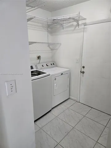 a utility room with cabinets washer and dryer