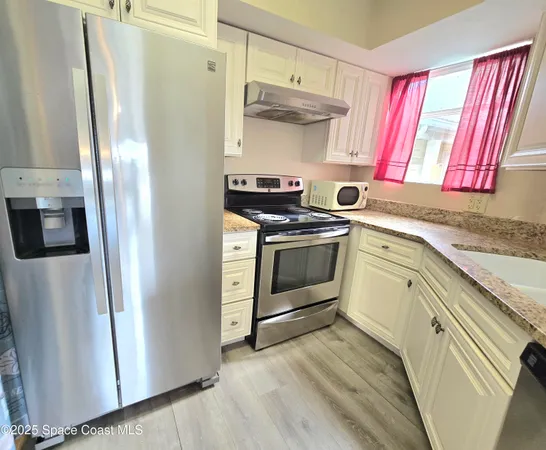 a kitchen with stainless steel appliances a stove a sink and a refrigerator