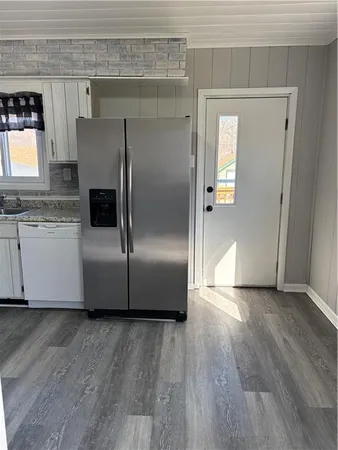 a kitchen with granite countertop a refrigerator and a sink