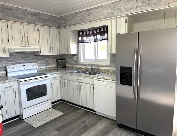 a kitchen with granite countertop white cabinets and white stainless steel appliances