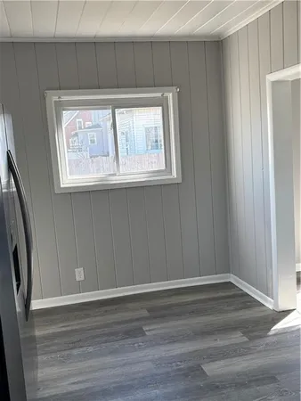 a view of a small space with wooden floor and a window