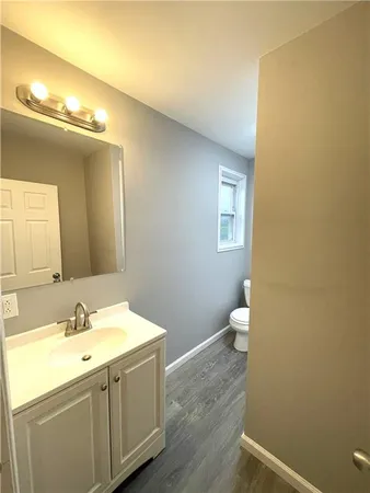 a bathroom with a sink mirror and a toilet