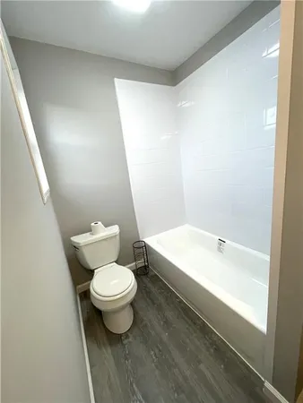 a white toilet sitting next to a white tub