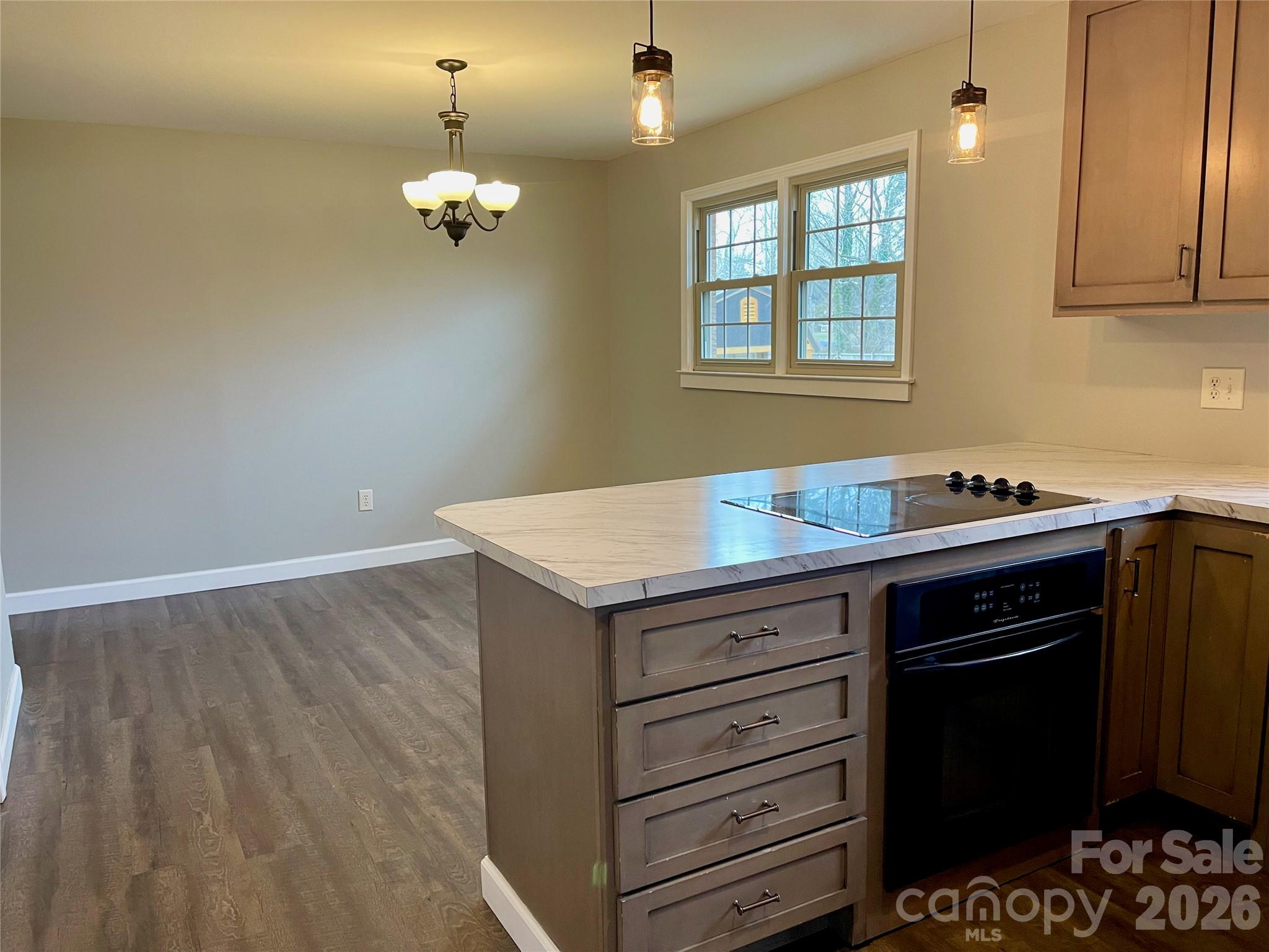 635 Powell Road Northeast Lenoir, NC 28645 - Photo 11 of 48 a kitchen with a wooden floor and cabinets