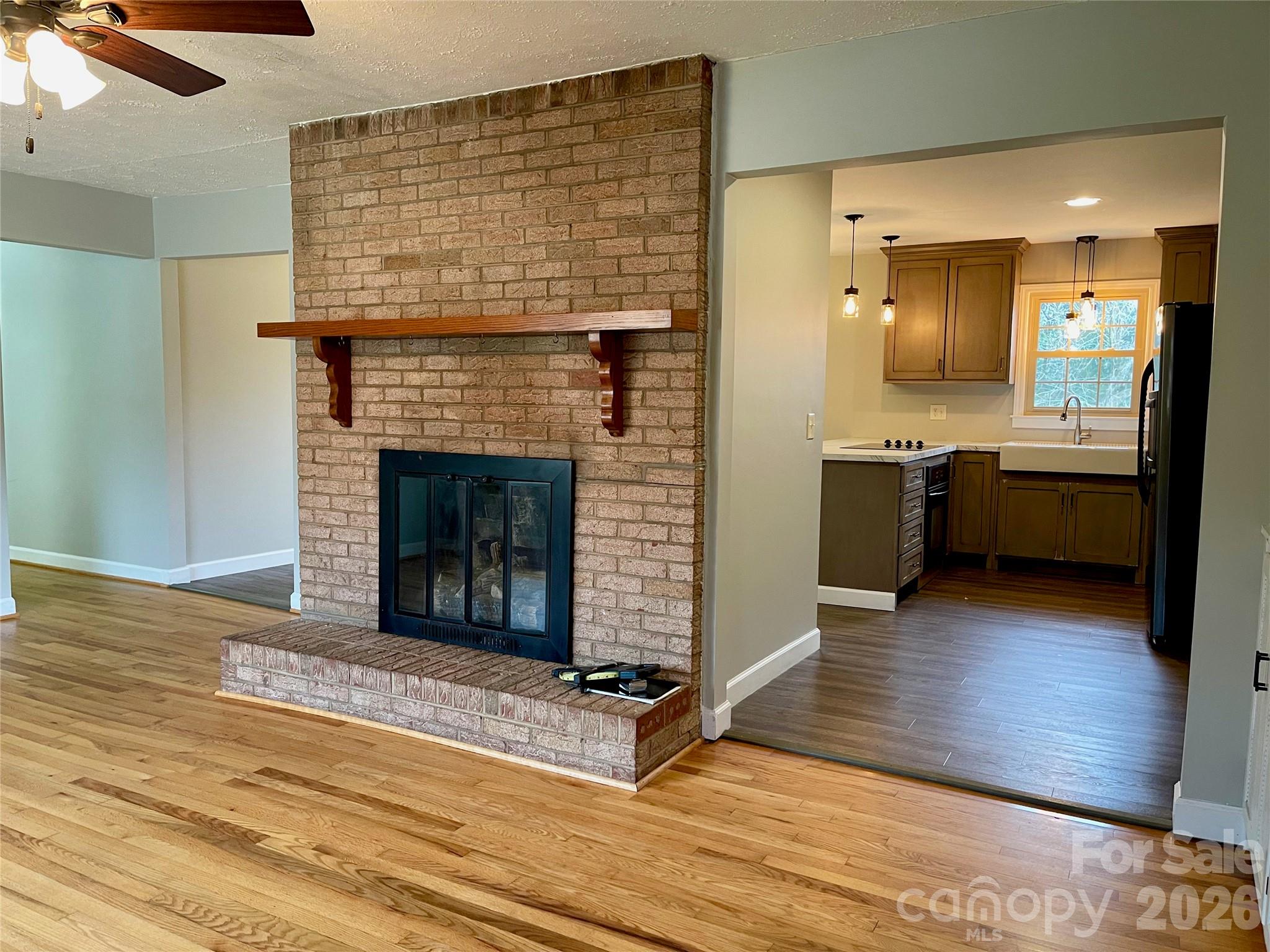 635 Powell Road Northeast Lenoir, NC 28645 - Photo 5 of 48 a living room with stainless steel appliances granite countertop furniture wooden floor and a fireplace