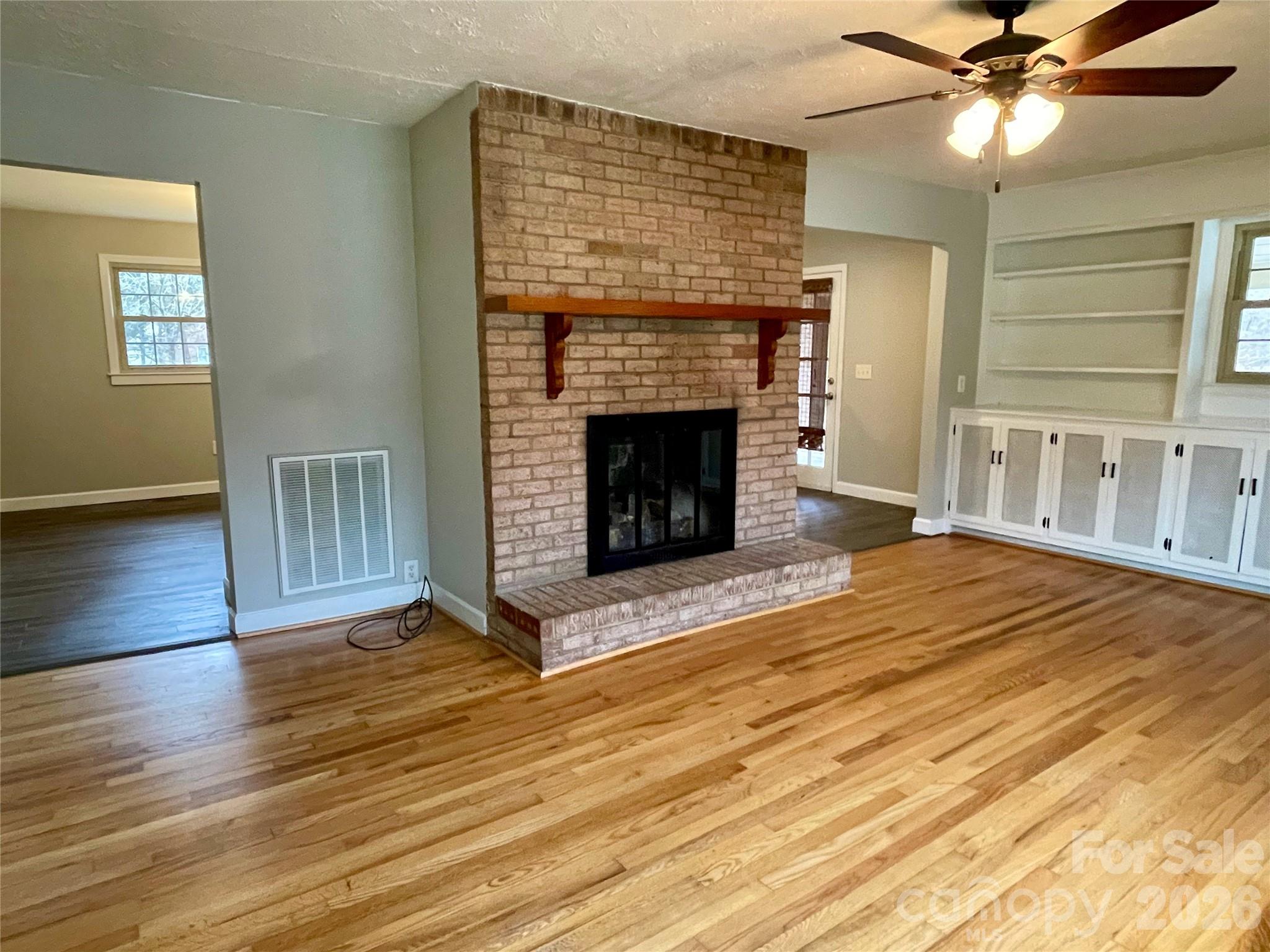 635 Powell Road Northeast Lenoir, NC 28645 - Photo 7 of 48 a living room with wooden floors and a fireplace