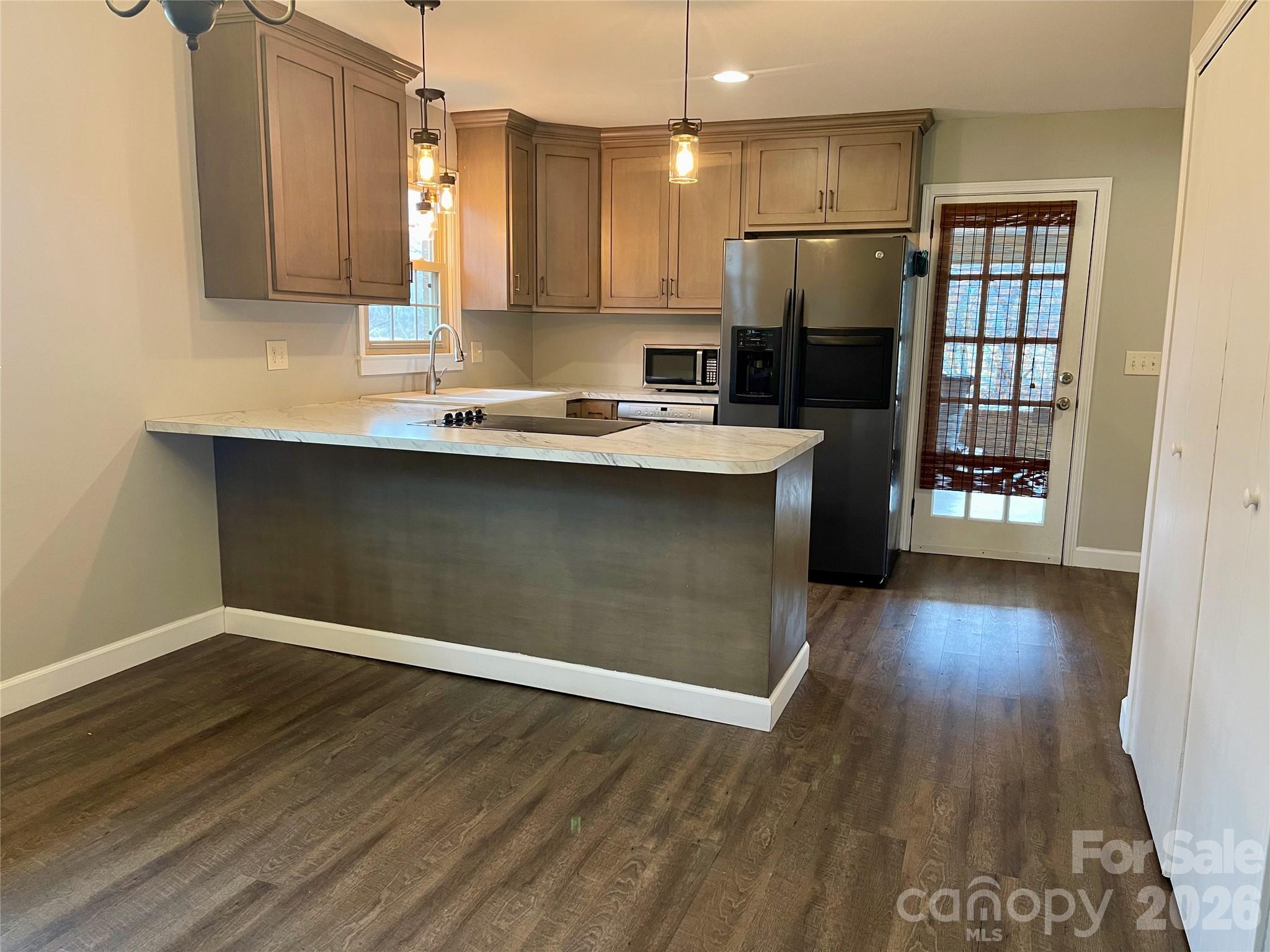 635 Powell Road Northeast Lenoir, NC 28645 - Photo 9 of 48 a kitchen with a sink a refrigerator and wooden floor