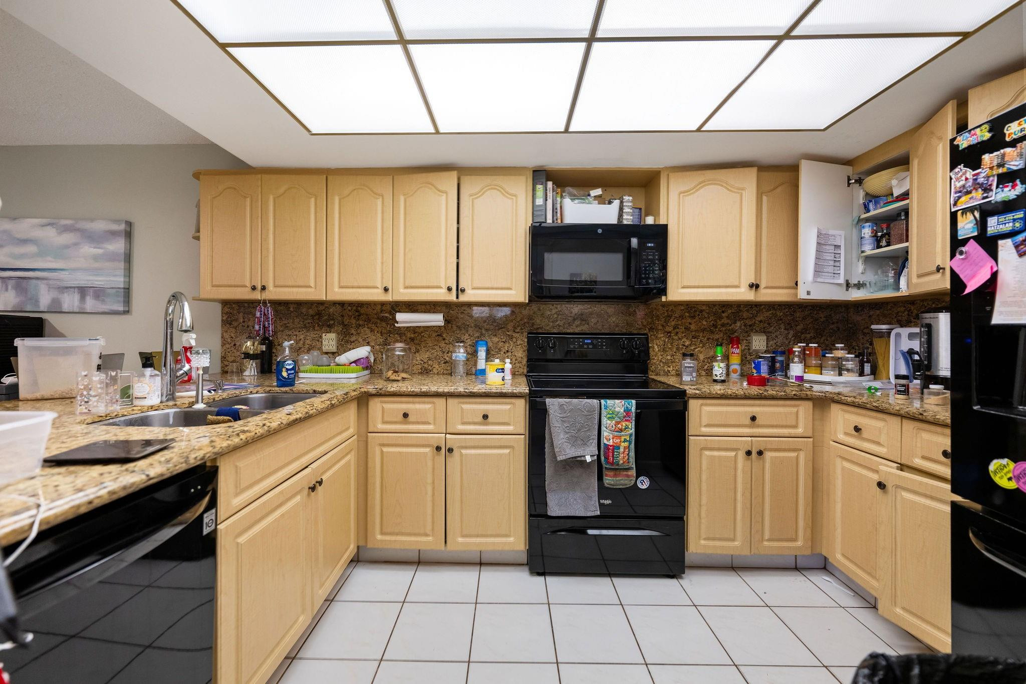 7427 Chablis Court Boca Raton, FL 33433 - Photo 3 of 12 a kitchen with stainless steel appliances granite countertop a stove a sink and a microwave