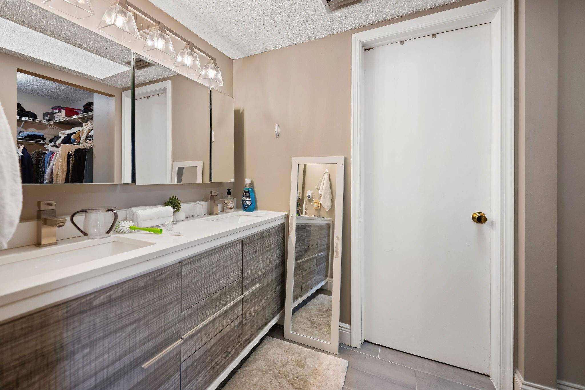 7427 Chablis Court Boca Raton, FL 33433 - Photo 9 of 12 a bathroom with a granite countertop sink a mirror and a shower